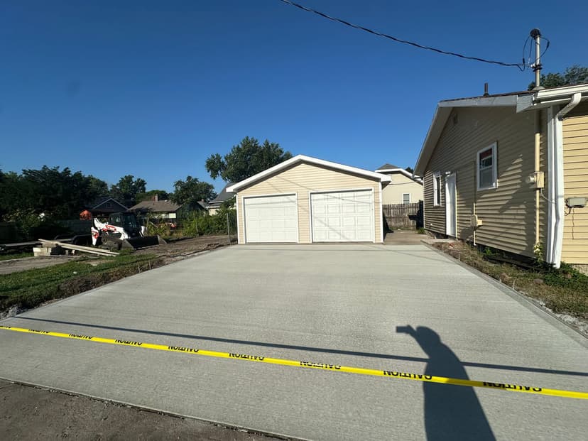 Newly poured concrete driveway with a two-car garage in a residential area.